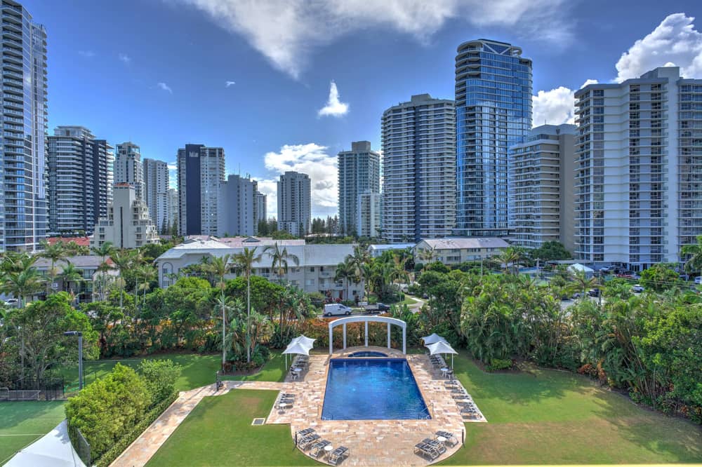 Outdoor pool and gardens at Contessa with surrounding lawn and palms