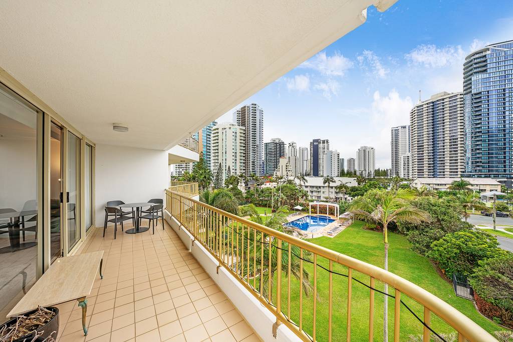 Balcony overlooking landscaped gardens, swimming pool and city buildings
