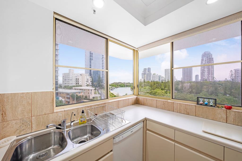 Kitchen sink and bench beneath windows overlooking the river and city