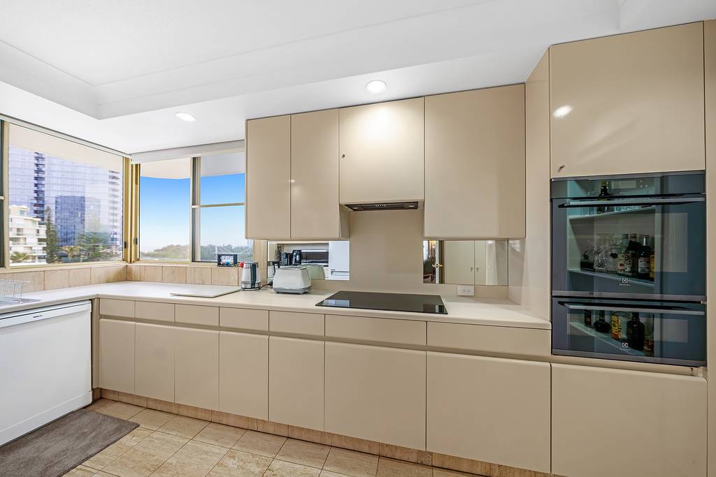 Apartment kitchen with electric cooktop, wall oven and wide windows