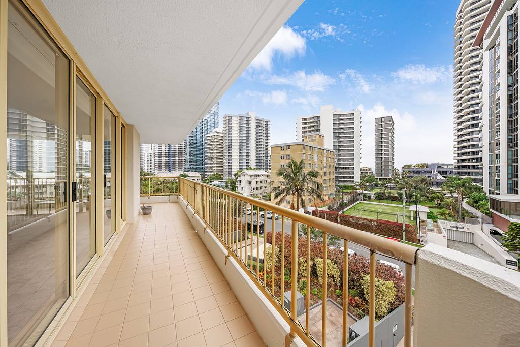 Wraparound balcony with outdoor table, chairs and city outlook