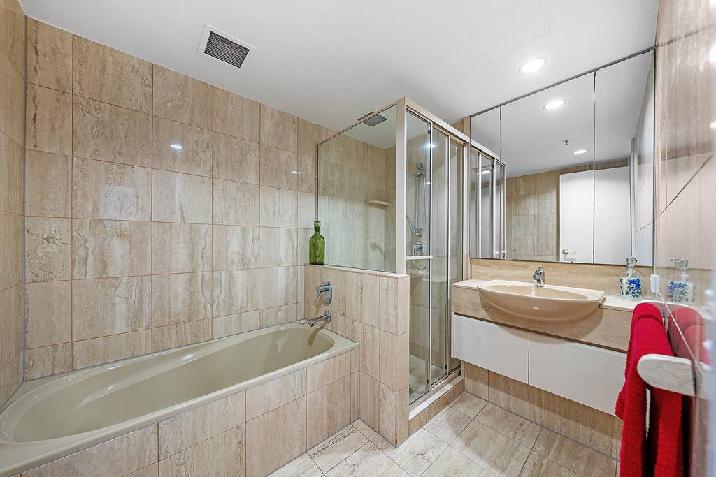 Bathroom with tiled bath, glass shower enclosure and vanity