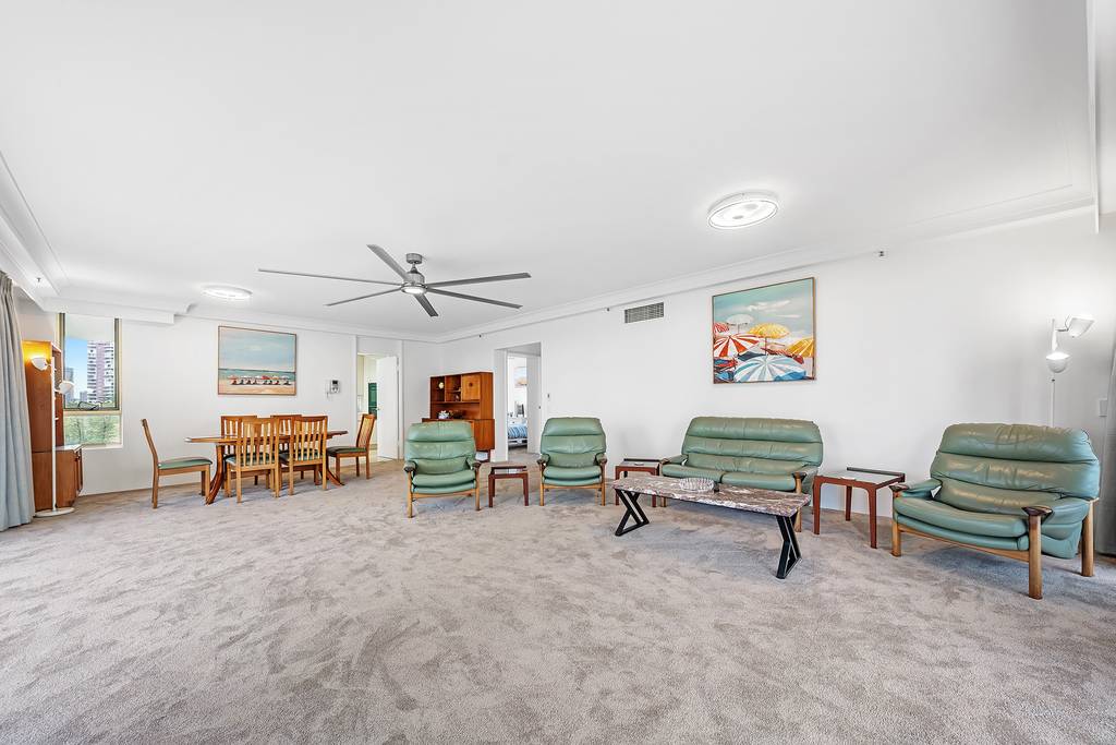 Open-plan living and dining room with leather seating and artwork