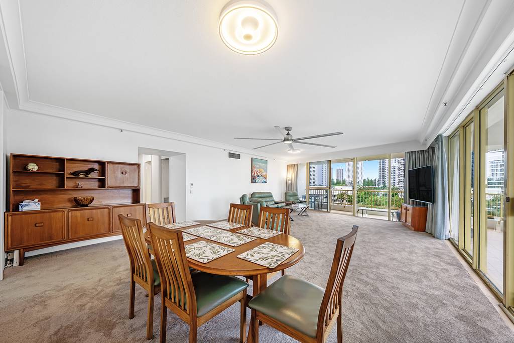 Living and dining room with timber table, leather seating and balcony