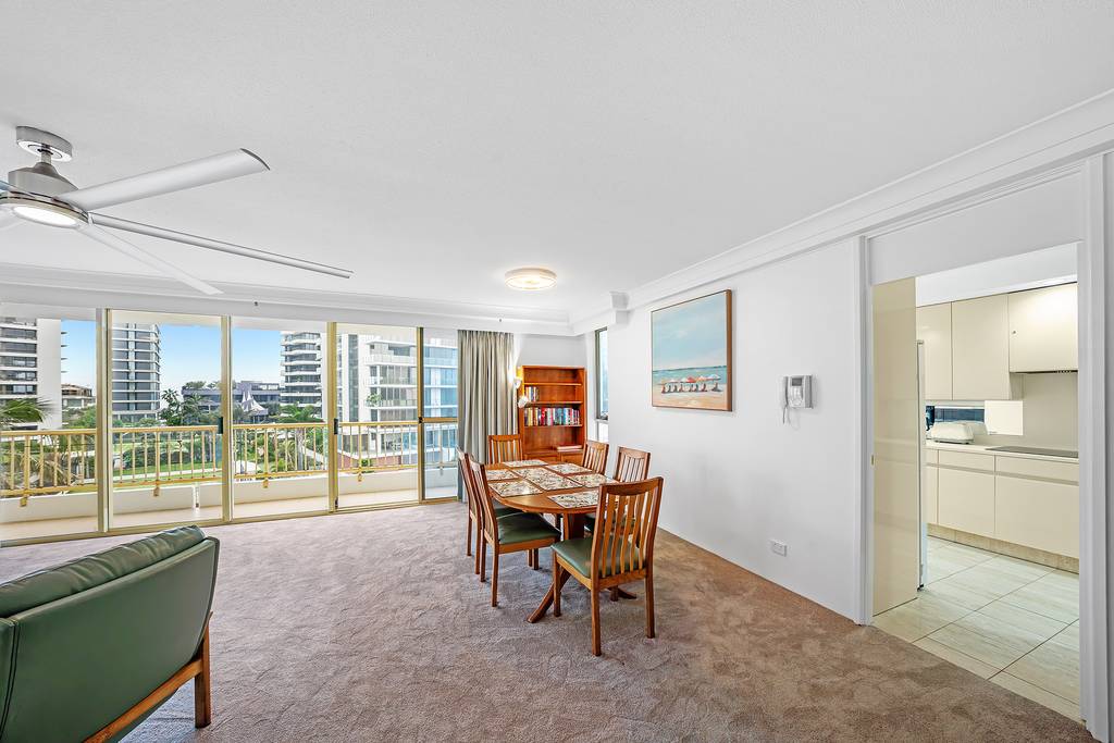 Living room dining area with balcony doors, bookshelf and artwork